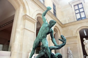 Escultura de bronce  de hombre luchando con serpiente.